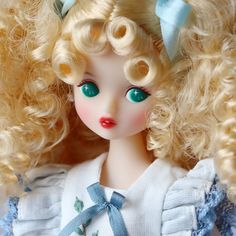 a close up of a doll with blonde hair