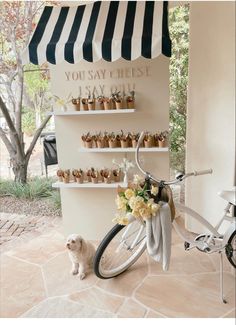 a bicycle parked next to a wall with cupcakes on it's rack