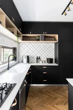 a kitchen with black cabinets and white counter tops