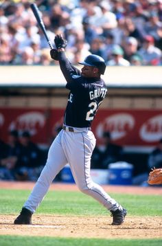 a baseball player holding a bat on top of a field in front of a crowd