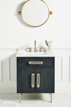 a bathroom with a sink, mirror and gold faucet on the wall above it