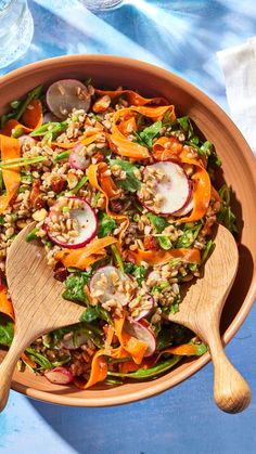 a salad with carrots, radishes and other vegetables in a wooden bowl