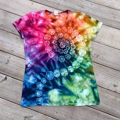 a t - shirt that has been dyed with different colors and shapes on the front