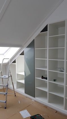 a room that has some shelves and ladders on the floor in front of it