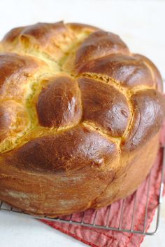 a loaf of bread sitting on top of a wire rack next to a red napkin