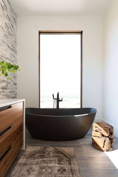 a large black bath tub sitting next to a window