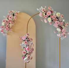 two tall pink and white flowers are in front of a mirror on the floor next to each other