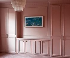 an empty room with pink walls and cabinets