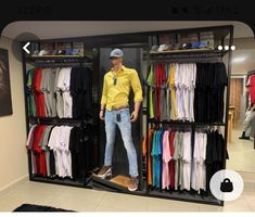 a man standing in front of a closet filled with clothes