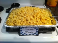 a metal pan filled with macaroni and cheese on top of a stovetop