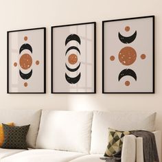 three framed pictures hang on the wall above a white couch