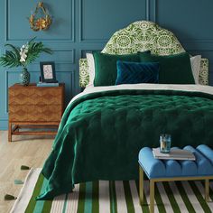 an image of a bedroom with blue walls and green bedspread on the bed