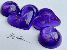 four purple hearts with dandelions on them