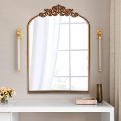 a white desk with a mirror and vase on it