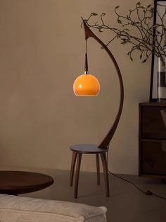 a lamp that is sitting on top of a wooden stand next to a chair and table