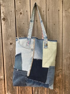 a bag made out of old jeans hanging on a wooden wall