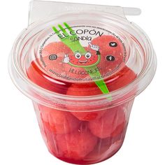 a plastic container filled with watermelon candies on top of a white surface