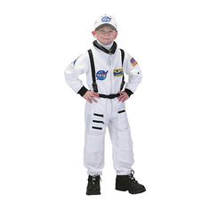 a young boy dressed in an astronaut suit and helmet, standing with his hands on his hips