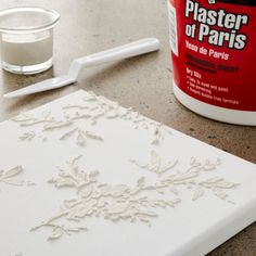 a table topped with white frosting next to a bottle of paint