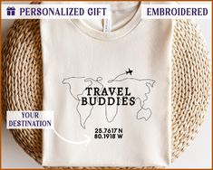 a t - shirt with the words travel buddies on it next to a woven basket