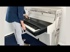 a man standing next to a white piano