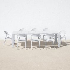 a white table and chairs sitting in front of a white wall with no one on it