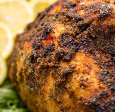 a close up of a chicken on a plate with lemons and broccoli