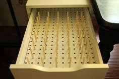 an open drawer with toothpicks stuck in it