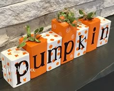 three pumpkin blocks with the word pumpkin painted on them