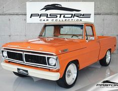 an orange and white truck parked in front of a sign