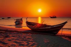 two boats are sitting on the beach at sunset or sunrise, with one boat in the foreground