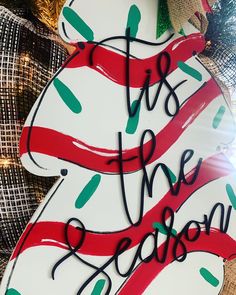 a christmas ornament with the words tis the season written on it in red, green and white