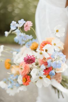 a bride holding a bouquet of flowers in her hands