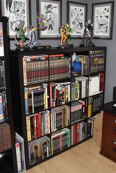 a book shelf filled with lots of books and figurines on top of it