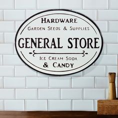 a sign that says general store ice cream soda and candy on the side of a white brick wall