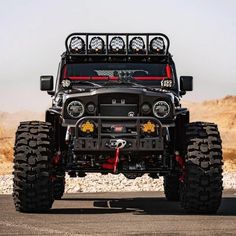 the front end of a black jeep with four lights on