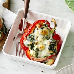 two small white dishes filled with food on top of a marble countertop next to each other