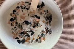 a white bowl filled with cereal and toppings on top of a cloth covered table