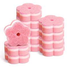 several pink sponges stacked on top of each other in front of a white background