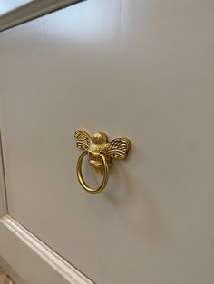 a bathroom door handle with a gold bee on it