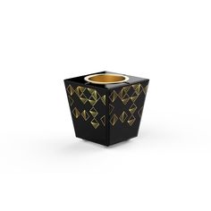 a black vase with gold geometric designs on the side and bottom, sitting in front of a white background