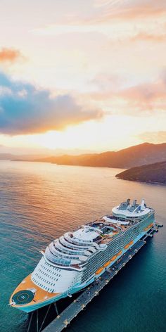 a large cruise ship in the ocean at sunset