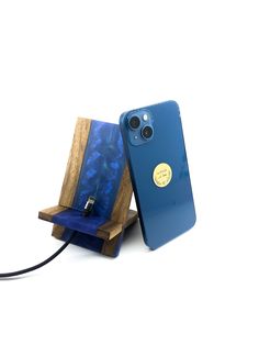 an iphone case is plugged into a wooden stand with a blue phone in it