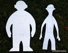 paper cut out of two people standing in the grass