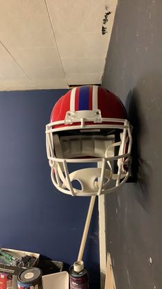 a football helmet mounted to the side of a wall next to cans of sodas