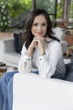 a woman sitting on top of a white couch