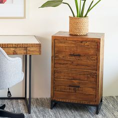 a plant sits on top of a wooden dresser next to a chair