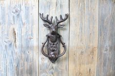 a metal deer head mounted to the side of a wooden wall