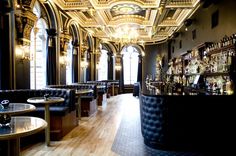 the interior of a restaurant with black leather booths and gold trimmings on the ceiling