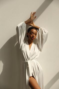 Our long bridal silk robe with wide long sleeves. It could be made of satin or pure mulberry silk. The robe is both casual and elegant, you may wear it on the hen party or spontaneously around your home on a daily basis. It is also an amazing outfit for your vocation, to wear it on the beautiful beach or by the pool as a cover up.-Our model wears size XS, her measurements are 82/61/87 cm and she is 172 cm tall.-Attached with belt.-Arrives beautifully packaged in tissue paper with ribbon -Length Satin V-neck Robe For Daywear, White V-neck Robe For Sleep, Elegant Long Sleeve Summer Sleepwear, Chic Silk Robe For Sleeping, Chic Long Sleeve Sleep Robe, Chic Satin Robe For Wedding Night, Elegant Silk Summer Robe, White Silk Wedding Nightgown, Elegant Open Front Daywear Robe